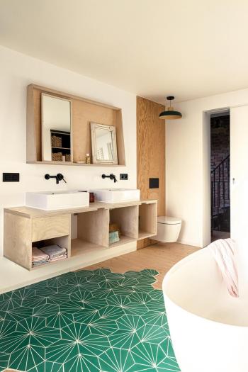 Rustgevende badkamer met groene accenten en houten meubels